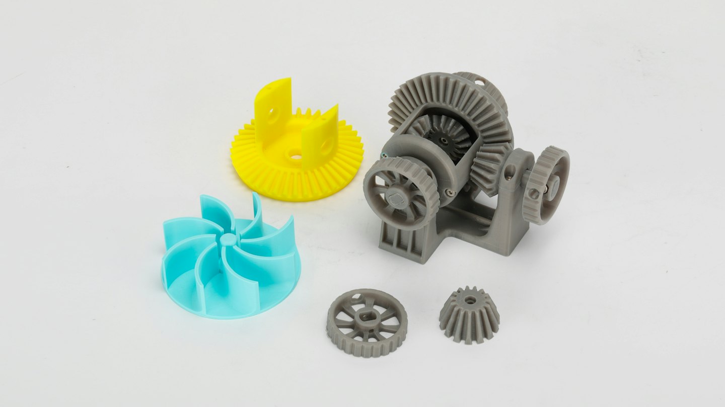 3D printed gears and fan components on a white background.